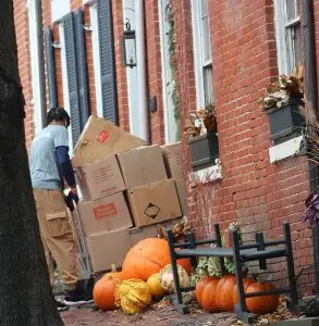 Envelop by McClain mover using a hand truck to move boxes outside a historic rowhome on Prince Street in Old Town Alexandria