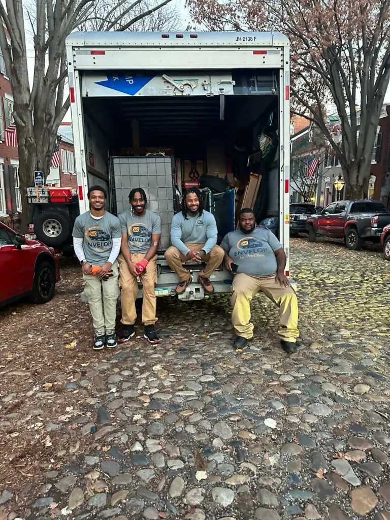Envelop by McClain moving crew sitting on the back of a truck on a historic cobblestone street in Old Town Alexandria after completing a residential move